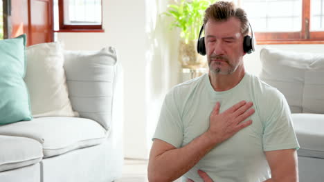 senior man meditating at home with headphones, finding peace and relaxation