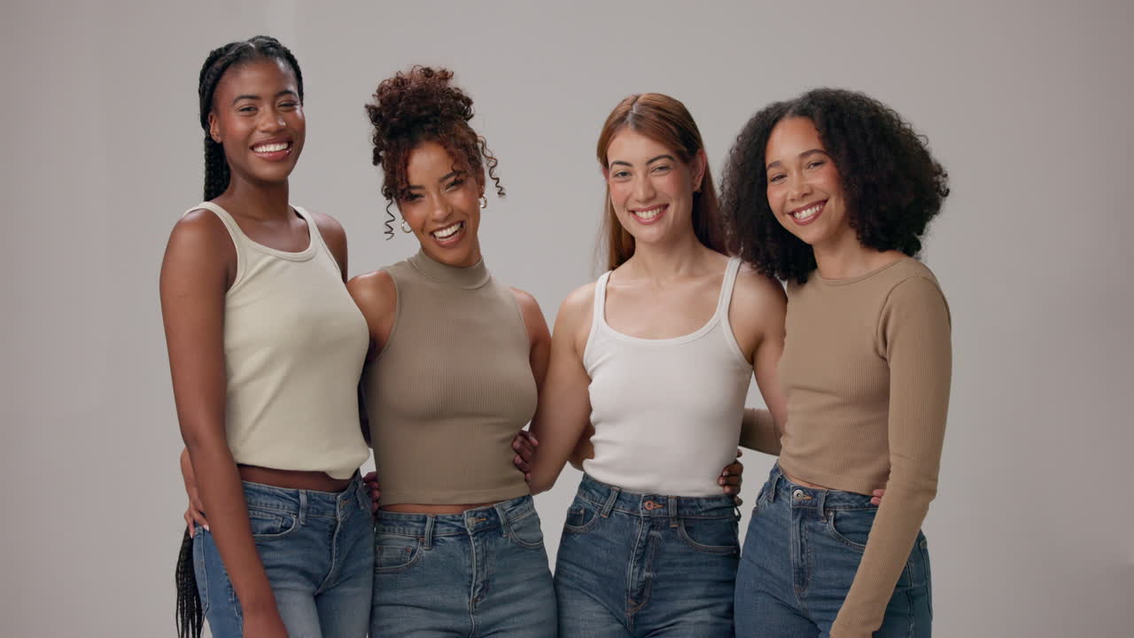 cuatro mujeres jóvenes diversas posan para una foto juntas, sonriendo y pareciendo felices.