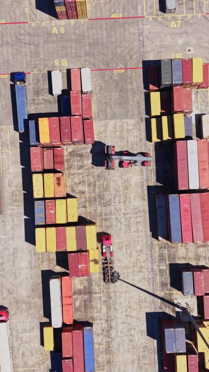 Containers stacked at a shipping yard during daytime work hours