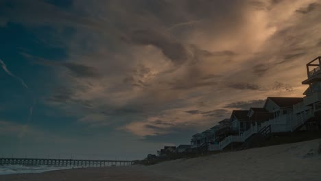 Sunrise-above-beach-bungalows-in-Surf-City,-Topsail-Island,-North-Carolina---colorful-time-lapse-cloudscape