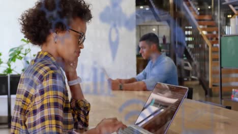 Animation-of-network-of-digital-icons-over-businesswoman-using-laptop-computer