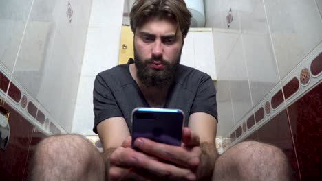 man using phone in a bathroom