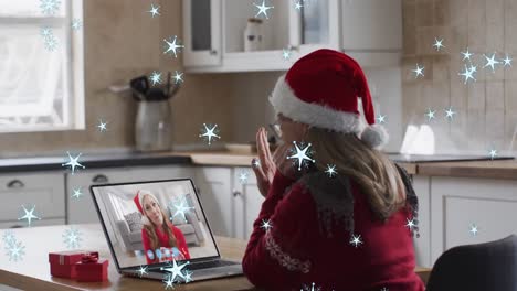 Animation-Von-Weihnachtssternen-über-Einer-Kaukasischen-Frau-Mit-Weihnachtsmütze-Auf-Einem-Laptop-Videoanruf-Mit-Der-Familie