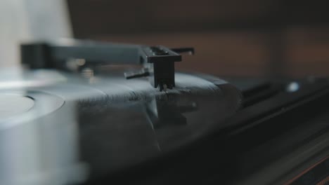 close-up: turntable needle on a vinyl record. male hand puts a needle.