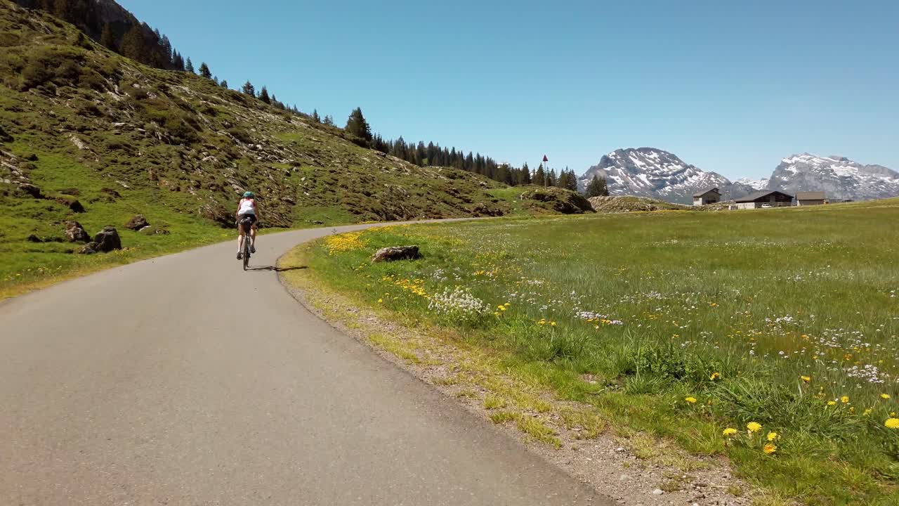 Tæt efter en cykelrytter, der slynger sig gennem det maleriske Pragelpas i Schweiz.