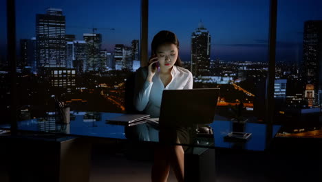 Professional Woman Working Late in High-Rise Office with City View