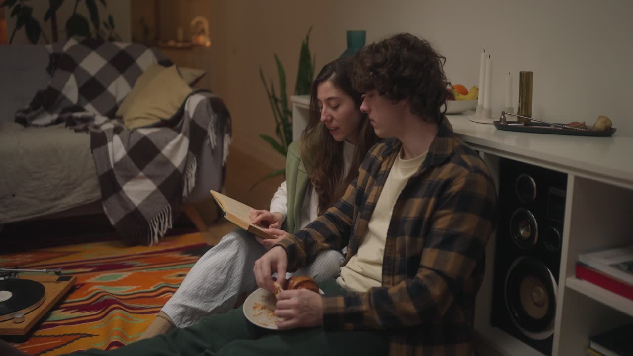 Couple Reading a Book and Relaxing Indoors