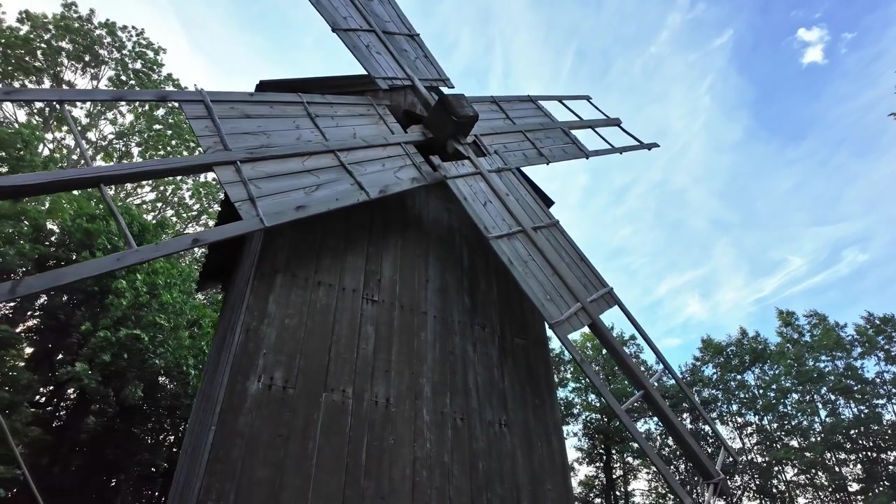 Traditional wooden windmill standing in a forest at the Estonian Open Air Museum in Tallinn, Estonia