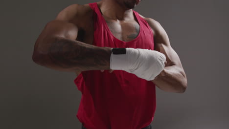 primer plano de un boxeador masculino envolviendo las manos con vendajes protectores antes de un partido de boxeo o una sesión de entrenamiento 3