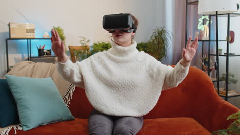 woman using virtual reality futuristic technology headset to play simulation 3d video game at home