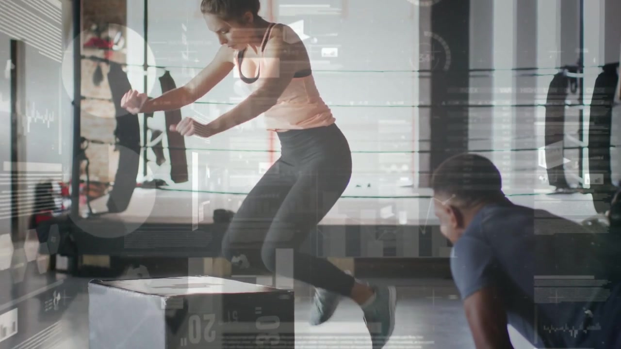 Female trainee performing explosive box jumps for fitness after male coach cueing with clipboard