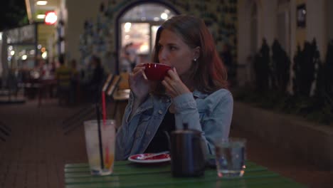 woman enjoying coffee at a night cafe