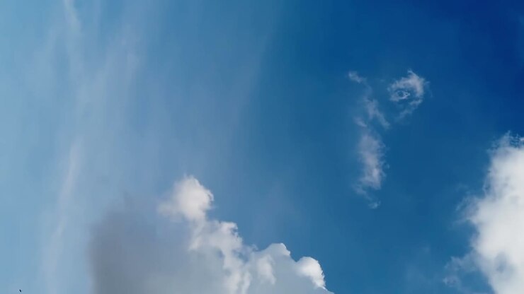 Sømløs loop af luftige skyer på en blå himmel, filmet en klar sommerdag