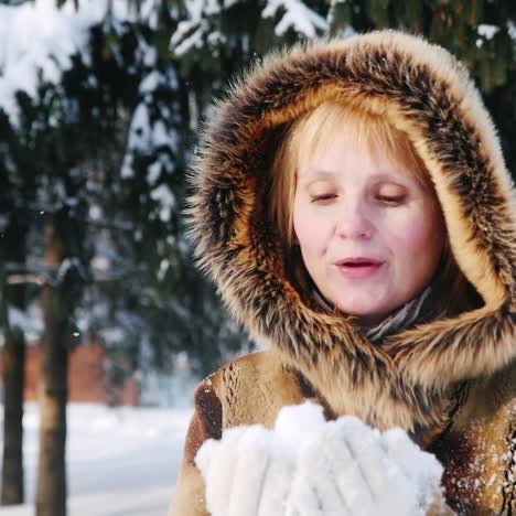 happy woman throws snow in the air and claps