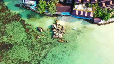 Luxury-bungalows,-in-the-Thailand-azure-sea,-with-white-sand-beach-and-granite-rocks-on-the-shore