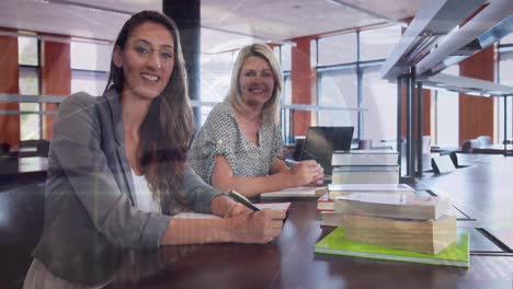 Animation-of-globe-and-programming-language-over-smiling-caucasian-teachers-sitting-in-school