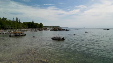 Luftüberflug-über-Wasser-Und-Große-Felsbrocken,-Um-Die-Küste-Der-Wildnis,-Den-Huronsee,-Die-Cheneaux-Inseln,-Michigan,-Freizulegen