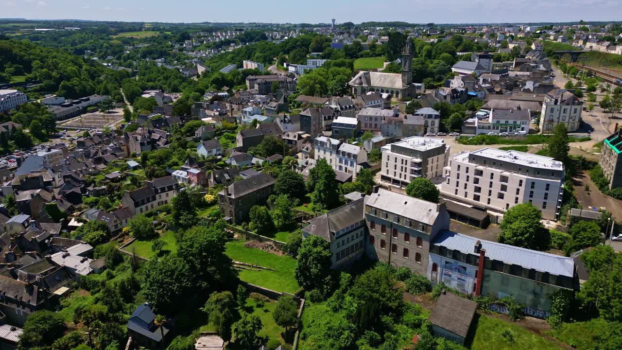 Historic town of Morlaix in Brittany, Saint Martin church, traditional architecture, and lush green landscape on sunny day, France. Aerial forward