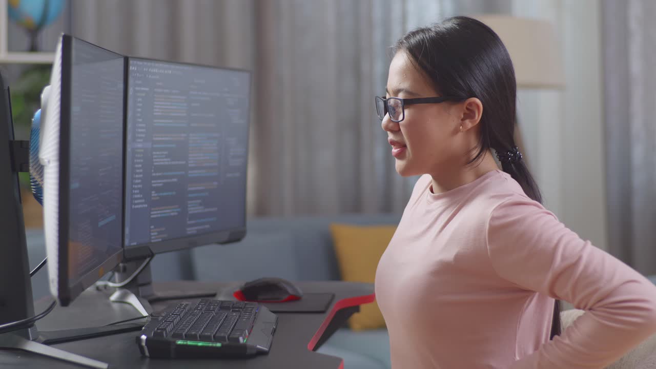 십대 아시안 소녀 프로그래머가 소프트웨어 엔지니어를 만들면서 허리 통증을 겪습니다. 집에서 데스크 컴퓨터에서 앱, 프로그램, 비디오 게임을 개발합니다. 코딩 언어를 가진 터미널