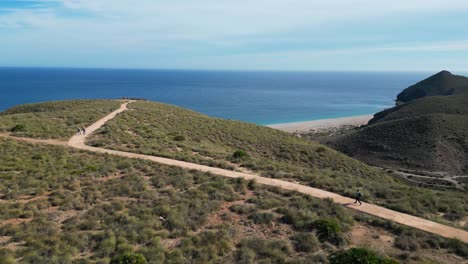 Mujer-Camina-A-La-Playa-De-Los-Muertos-En-Cabo-De-Gata,-Andalucía,-España---Antena-4k