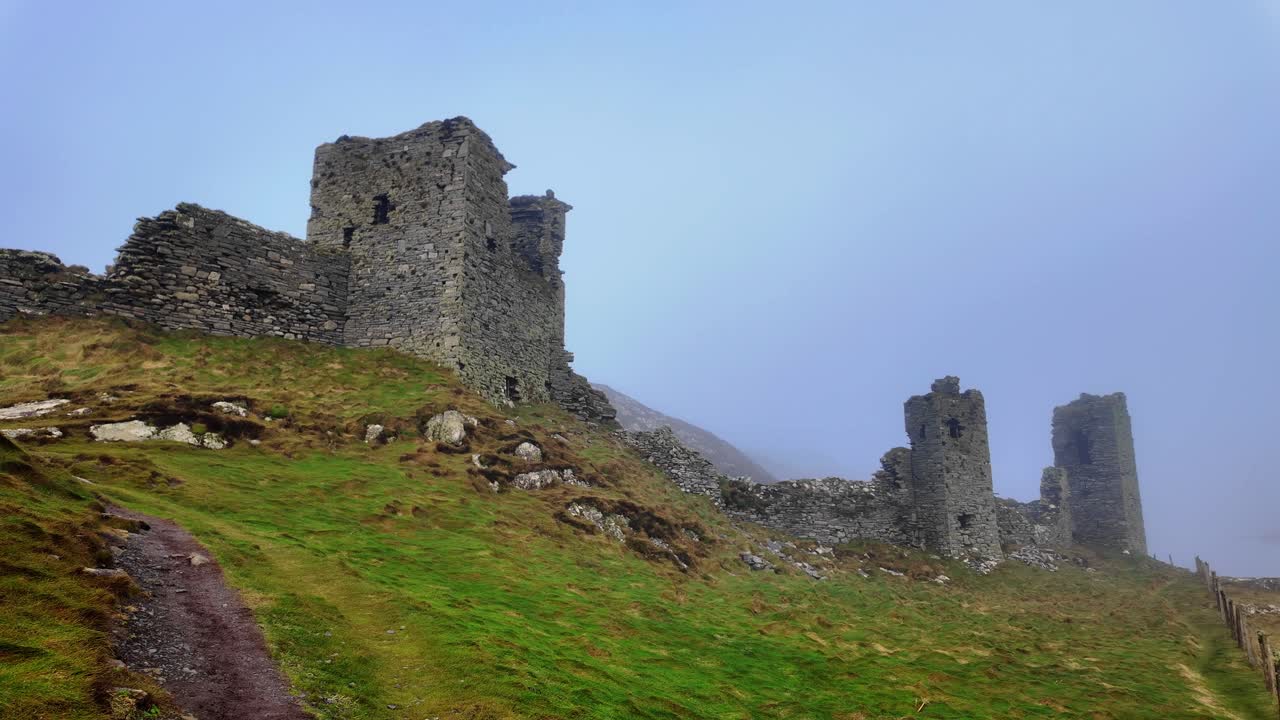 The trail to the castle romantic ruins of £ castle Head appears out of the winter mist mystical Irish landscape in winter