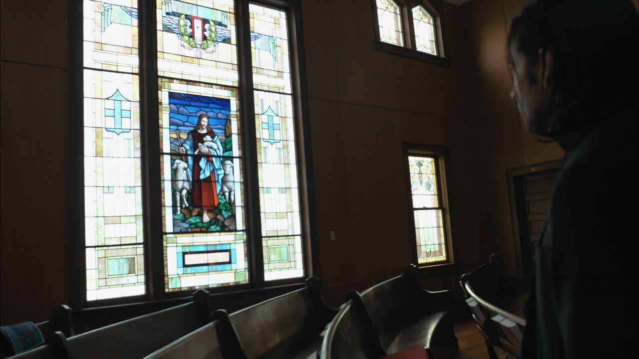 A Christian man, priest, preacher, pastor in spiritual reflection and worship while praying inside old church building, creating a cinematic and contemplative mood