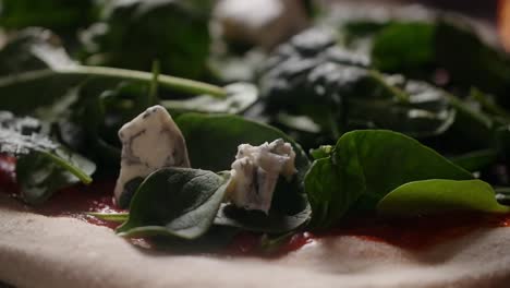 close-up of a pizza with spinach and gorgonzola cheese