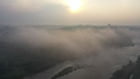 misty sunrise over a river and forest
