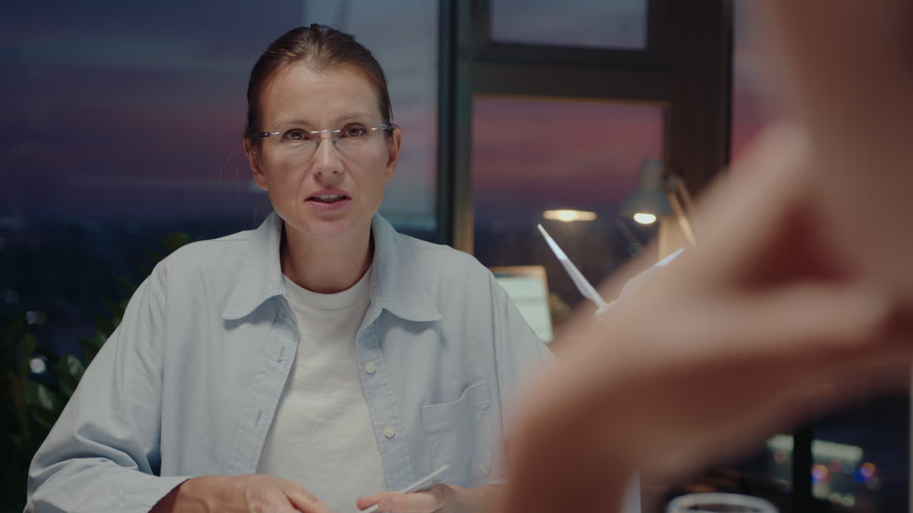 ingeniera discutiendo un proyecto de energía limpia con sus compañeros de trabajo durante una reunión de negocios por la noche.