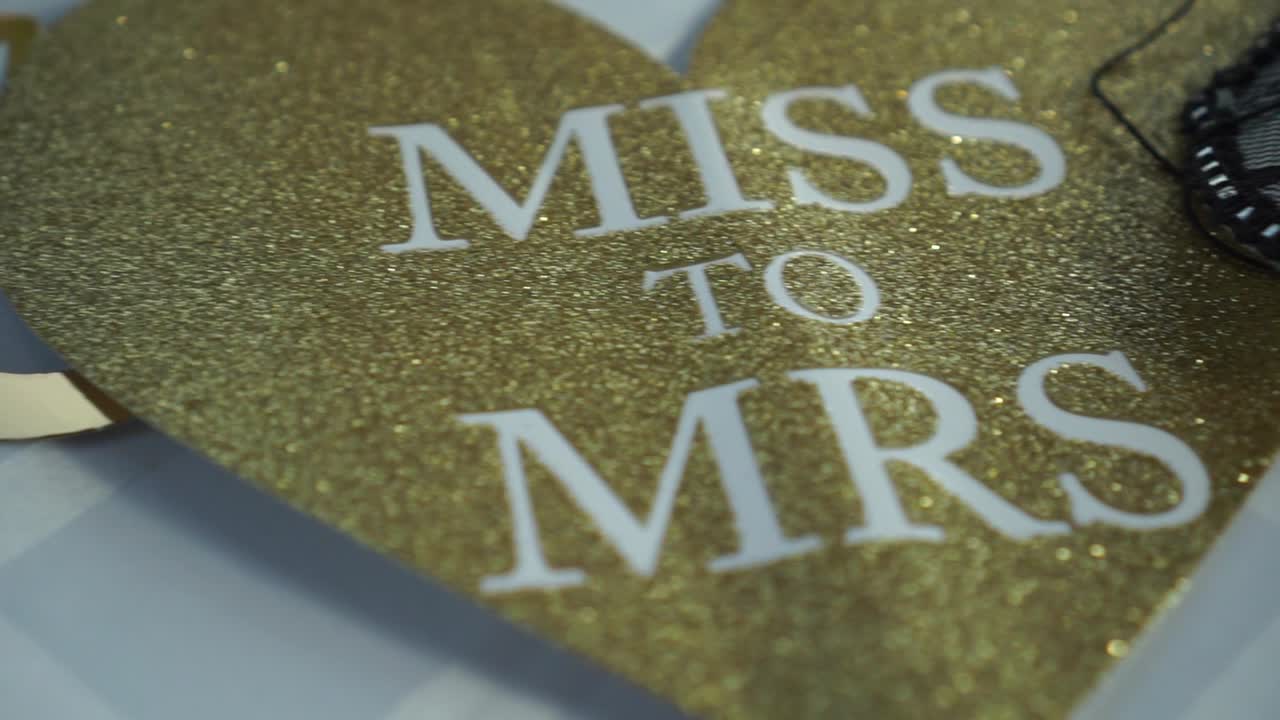 slowmo - goldene hochzeitskarte herr und frau in herzform auf weißem tisch