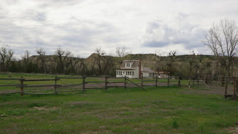 ranch house on the prairie with wooden fence and cloudy sky