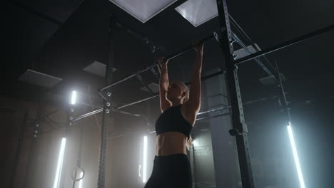 entrenamiento con barra cruzada en el gimnasio mujer está cambiando y viviendo las piernas hacia arriba tensando los músculos abdominales de trabajo