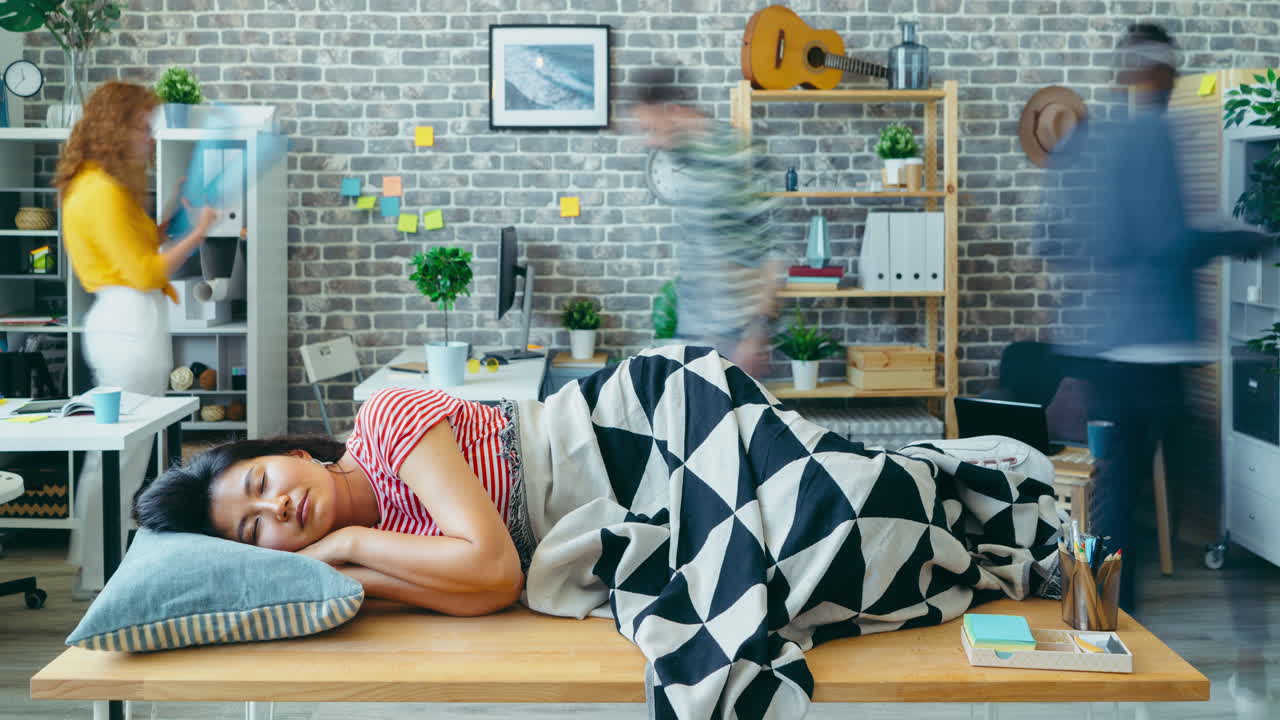 Woman Taking a Nap at Her Desk in a Modern Office