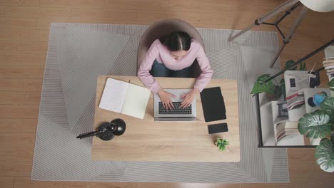 mujer trabajando desde casa en una computadora portátil