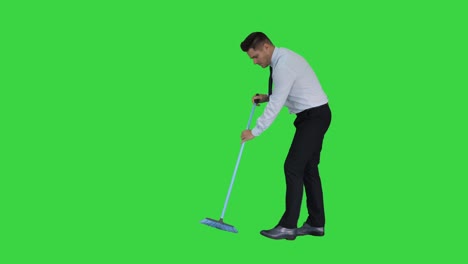 hombre en ropa oficial barriendo el suelo en una pantalla verde, clave de croma