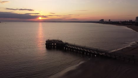 circular ending dock quay of punta del este in uruguay with beach coastline and city skyline in background at sunset