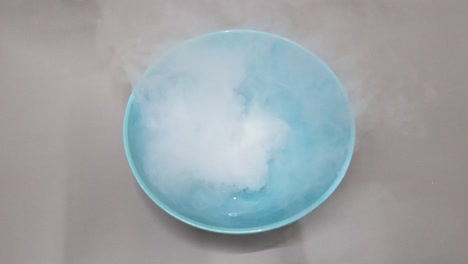 dry ice sublimating in water with vapor clouds