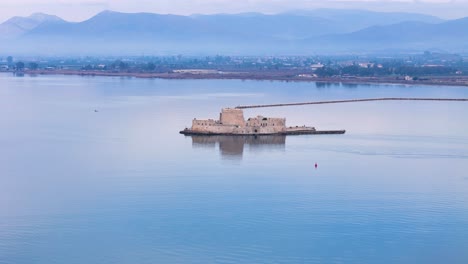 Vista-Aérea-Giratoria-Del-Majestuoso-Castillo-Acuático-De-Bourtzi-En-La-Hermosa-Región-Del-Peloponeso,-Grecia