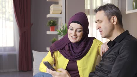 Muslimische-Familie-Schaut-Zu-Hause-Auf-Das-Telefon.