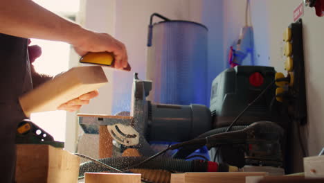 especialista en carpintería que utiliza papel de lija manual para pulir la madera