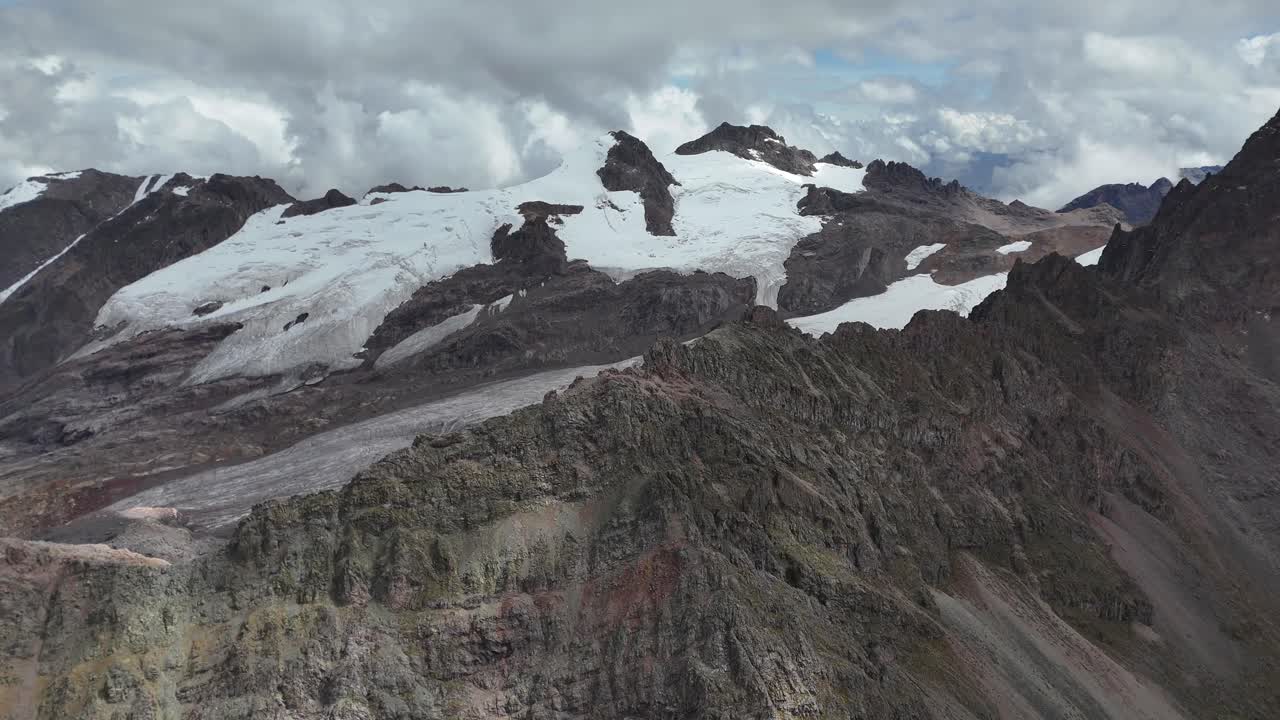Majestic Snow-Capped Mountains and Glaciers Under a Cloudy Sky