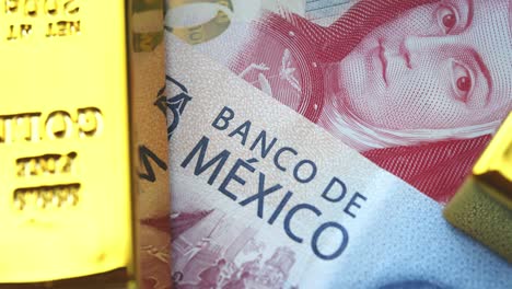 close up to mexican currency with gold bars around.