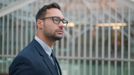 Thoughtful-30-Year-Old-French-Businessman-In-Glasses-Walking-In-The-City-By-Office-Building---close-up-tracking-shot