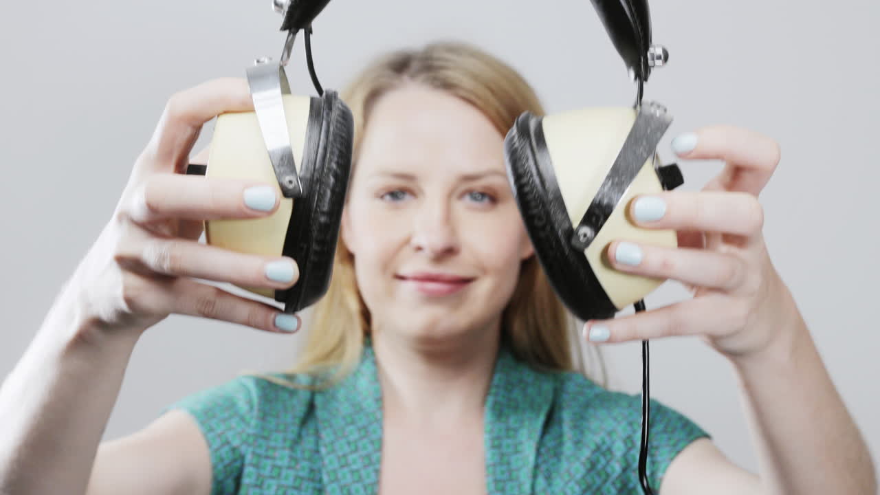 cool female dancer with changing retro headphones to listen to music