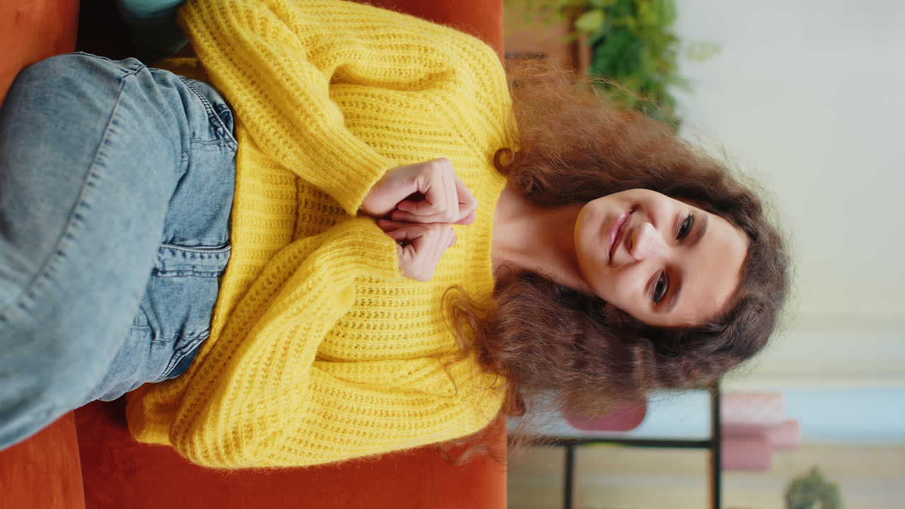 Child kid girl smiling friendly at camera waving hands gesturing hello hi greeting at home on couch