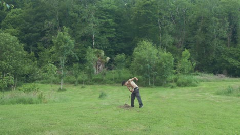 topless man rakes hay in field alone