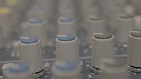 extreme close up of audio mixer knobs in recording studio