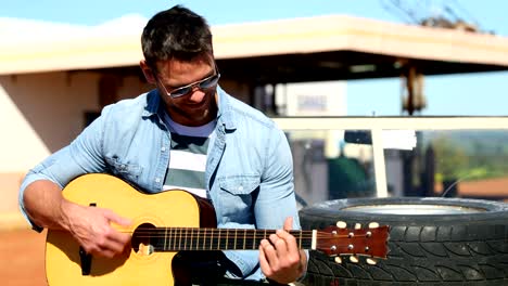 man playing guitar while sitting on car 4k