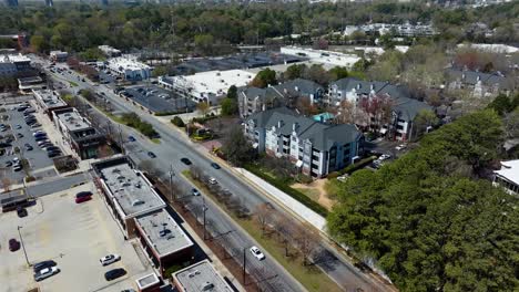 aerial view of shopping center, parking cars, traffic on road and modern hotel apartments with swimming pool. atlanta suburb district in spring.