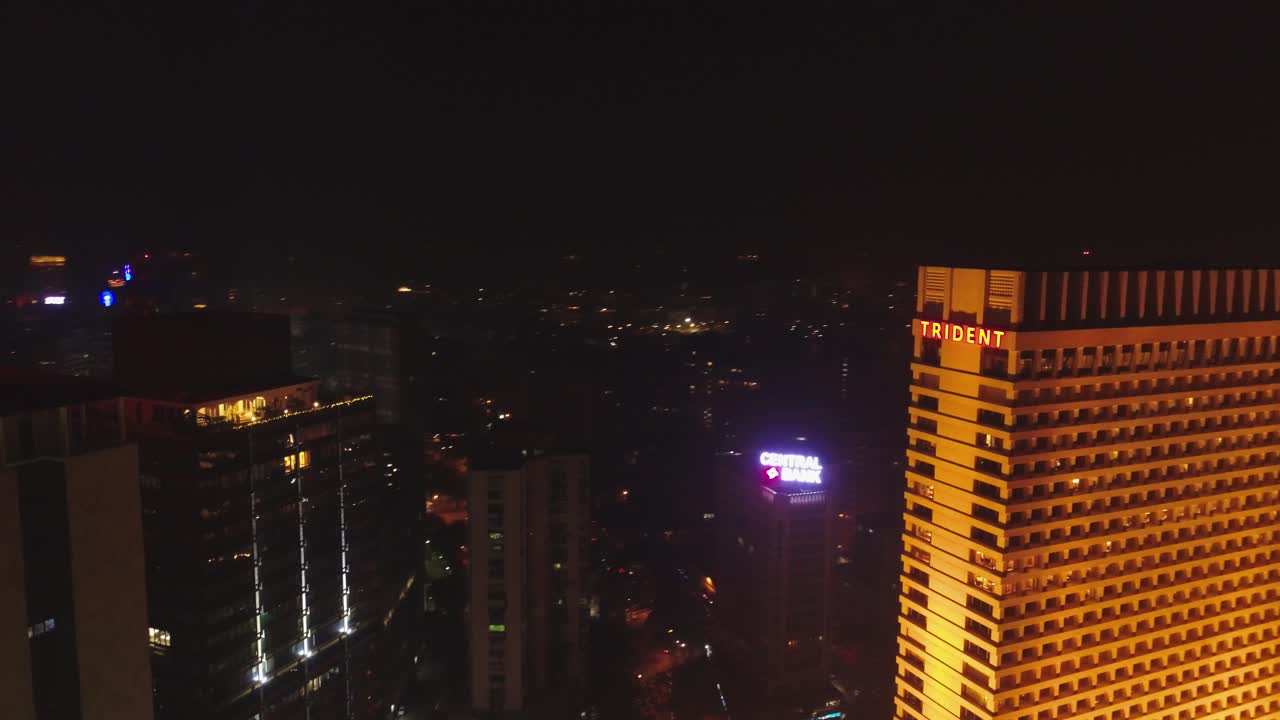 An aerial view with cinematic drone movement of the iconic Marine Drive nightlife with Air India and Trident Hotel buildings in sight.